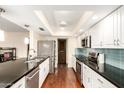 Modern kitchen featuring dark countertops, stainless steel appliances, and wood flooring at 5926 S Newberry Rd, Tempe, AZ 85283