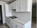 Bright kitchen with white cabinets, tile floors and stainless steel sink at 6901 W Mackenzie Dr # 1287, Phoenix, AZ 85033