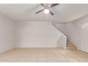 Living room features neutral walls, tile flooring, and access to the stairs at 6901 W Mackenzie Dr # 1287, Phoenix, AZ 85033