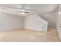 Living room features neutral walls, tile flooring, and access to the stairs at 6901 W Mackenzie Dr # 1287, Phoenix, AZ 85033