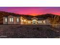 Exterior view of a single-story home with desert landscaping and a vibrant sunset sky at 9357 W Canyon Verde Dr, Casa Grande, AZ 85194