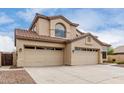 Inviting two-story home featuring a three-car garage, desert landscaping, and a tile roof at 9825 E Gary St, Mesa, AZ 85207