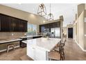 Modern kitchen with a large marble island, stainless steel appliances, and dark wood cabinetry at 10623 E Acacia Dr, Scottsdale, AZ 85255