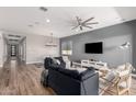 Spacious living room boasts wood floors, recessed lighting, modern ceiling fan, and contemporary furnishings at 10949 N 183Rd Dr, Surprise, AZ 85388