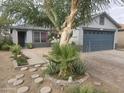 Beautiful landscaped front yard with brick-paved driveway and mature trees at 11770 W Aster Dr, El Mirage, AZ 85335