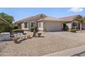 Well-maintained single-story home with desert landscaping, a bench, and a two-car garage at 1241 E Elm Rd, San Tan Valley, AZ 85140