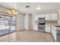Bright kitchen with white cabinets, stainless steel appliances, and a sliding glass door to the patio at 15802 W Watson Ln, Surprise, AZ 85379