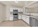 Spacious kitchen features stainless steel appliances, white cabinets, and tile backsplash at 15802 W Watson Ln, Surprise, AZ 85379