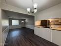 Eat-in kitchen with dark flooring, a chandelier, and white cabinets for a light and airy feel at 1723 W Cheryl Dr, Phoenix, AZ 85021
