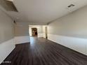 Spacious living room featuring wood-look flooring and a glimpse of the fireplace in the background at 1723 W Cheryl Dr, Phoenix, AZ 85021