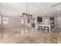 Bright, open-concept living/dining area with tile flooring and breakfast bar at 18658 N Tanners Way, Maricopa, AZ 85138
