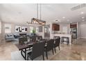 Open-concept living/dining area showcases modern lighting, dining table, and comfortable furnishings at 18658 N Tanners Way, Maricopa, AZ 85138
