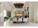 Open-concept dining area with modern chandelier, sliding glass doors, and view of the backyard at 19917 E Natalie Way, Queen Creek, AZ 85142