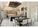 Elegant dining area with modern chandelier and spacious kitchen in a well-lit, open-concept design at 19917 E Natalie Way, Queen Creek, AZ 85142