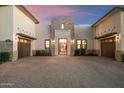 Close up of the front exterior featuring a paver driveway, three-car garage and stone entrance at 19917 E Natalie Way, Queen Creek, AZ 85142