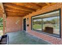 Inviting front porch featuring brick columns, a large window, and a glimpse of the grassy front yard at 20 W Pasadena Ave, Phoenix, AZ 85013