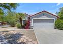 Charming single-story home with a two-car garage, xeriscape landscaping, and mature desert plants at 2028 W Alice Ave, Phoenix, AZ 85021