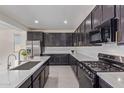 Sleek kitchen boasts stainless steel appliances, dark cabinets, and a functional layout at 22876 E Via Del Sol --, Queen Creek, AZ 85142
