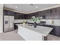 Modern kitchen features a spacious island, stainless steel appliances, and dark cabinetry at 22876 E Via Del Sol --, Queen Creek, AZ 85142