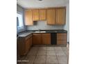 An efficient kitchen featuring tile floors, wood cabinets, and black countertops at 25 W Illini St, Phoenix, AZ 85041
