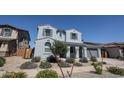 Beautiful two-story home with a light blue exterior, grey shutters, and desert landscaping at 25051 N 140Th Dr, Surprise, AZ 85387