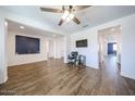 Bright living room features wood-look tile floors, a ceiling fan, and modern recessed lighting at 25051 N 140Th Dr, Surprise, AZ 85387