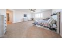 A spacious main bedroom featuring a ceiling fan, carpeted floors, a TV and a desk area at 25051 N 140Th Dr, Surprise, AZ 85387