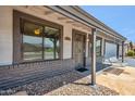 Inviting front entry featuring a stylish security door, covered porch, and a charming front porch swing at 2708 E Villa Theresa Dr, Phoenix, AZ 85032