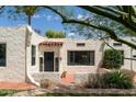 Charming home featuring stucco exterior, a red tile roof detail, black trimmed windows, and well-manicured landscaping at 356 W Roma Ave, Phoenix, AZ 85013