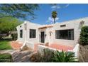 Charming home featuring stucco exterior, a red tile roof detail, black trimmed windows, and well-manicured landscaping at 356 W Roma Ave, Phoenix, AZ 85013