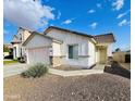 Attractive single-story home with desert landscaping, a two-car garage, and a well-manicured lawn at 4891 E Meadow Mist Ln, San Tan Valley, AZ 85140