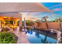 A backyard oasis featuring a beautiful pool with rock waterfall features and lush landscaping at 4960 E Colonial Dr, Chandler, AZ 85249