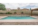 Inviting pool area with a water feature and comfortable lounging area surrounded by lush landscaping at 9041 W Redbird Rd, Peoria, AZ 85383