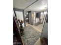 Hallway featuring grey walls and flooring, as well as the laundry area and a bedroom at 9501 E Broadway Rd # 21, Mesa, AZ 85208
