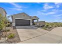 Well-maintained home with desert landscaping, spacious driveway, and a two-car garage at 10004 S Smythe Dr, Apache Junction, AZ 85120