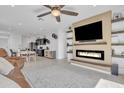 Open-concept living room featuring a modern fireplace, ceiling fan, and neutral decor at 10004 S Smythe Dr, Apache Junction, AZ 85120