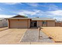 Charming single-story home with a two-car garage, brick walkway, and manicured front yard at 1002 W Villa Rita Dr, Phoenix, AZ 85023