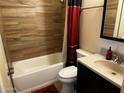 Cozy bathroom with wood-look tiled walls, a shower-tub combination, and modern vanity at 1126 W Elliot Rd # 1058, Chandler, AZ 85224
