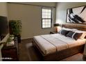 Modern bedroom features a large bed with stylish bedding, a window, and a decorative plant at 1126 W Elliot Rd # 1058, Chandler, AZ 85224