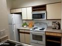 Functional kitchen with white appliances, ample cabinet space, and a clean, efficient layout at 1126 W Elliot Rd # 1058, Chandler, AZ 85224