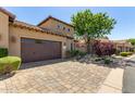 Exterior of home featuring a two-car garage, desert landscaping, and brick paver driveway at 1508 N Alta Mesa Dr # 120, Mesa, AZ 85205