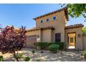Charming home exterior featuring a two-car garage, desert landscaping, and stone pathway to the front courtyard at 1508 N Alta Mesa Dr # 120, Mesa, AZ 85205
