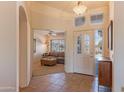 Inviting foyer with tile flooring, view into living room, and a bright front door at 15371 W Piccadilly Rd, Goodyear, AZ 85395