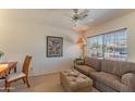 Cozy living room featuring a comfortable couch, ottoman, and a peaceful view at 15371 W Piccadilly Rd, Goodyear, AZ 85395