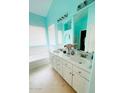 Bright bathroom featuring double sinks, a large mirror, and a bathtub at 15897 N Gil Balcome St, Surprise, AZ 85374