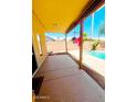 View of the covered patio leading to a refreshing pool and vibrant landscaping at 15897 N Gil Balcome St, Surprise, AZ 85374