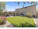Beautiful backyard with green grass, a pergola-covered patio, and tasteful landscaping for outdoor enjoyment at 18390 W Hayden Dr, Surprise, AZ 85374