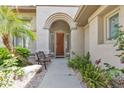 Inviting front entrance with an arched doorway, wood door, and charming bench at 1951 W Bartlett Ct, Chandler, AZ 85248