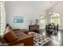 Bright living room featuring vaulted ceiling, hardwood floors, and a decorative area rug at 2026 E Cortez Dr, Gilbert, AZ 85234