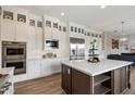 Bright kitchen with custom white cabinetry, stainless steel appliances, and a large kitchen island at 22925 N 46Th St, Phoenix, AZ 85050